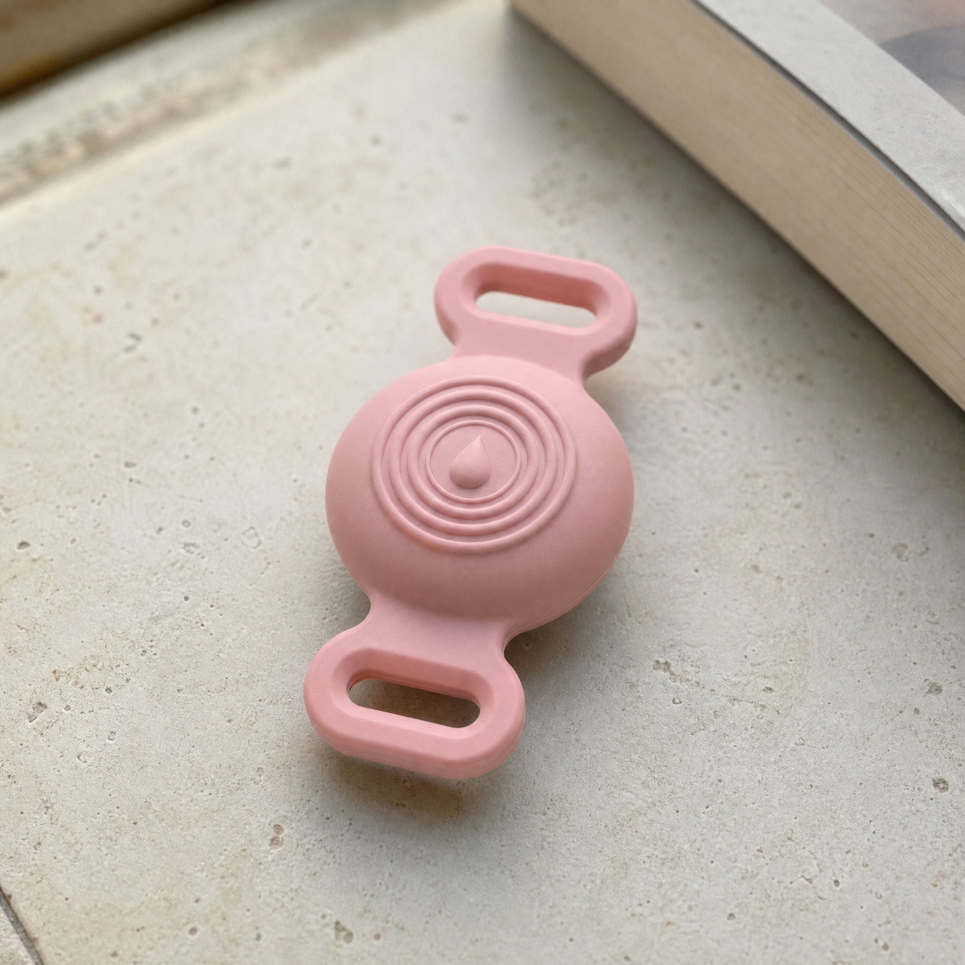 TailTrace mount in blush pink on a stone sill
