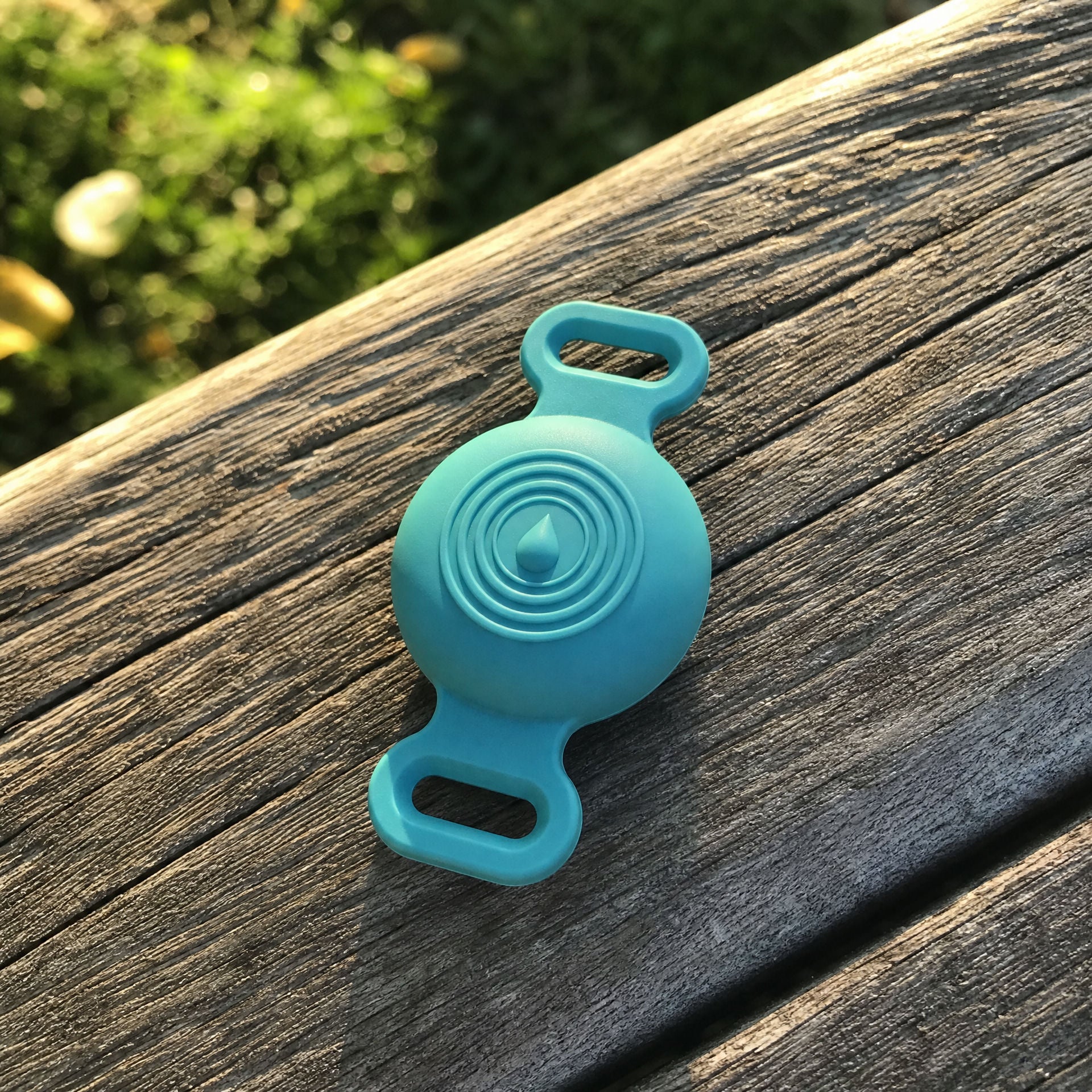 TailTrace mount in teal on a weathered outdoor bench